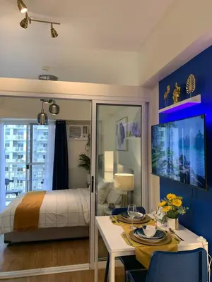 a bedroom with a bed and a table with plates on it at CASA ROYALE Affordable Condo Near BGC Ortigas Center CBD in Manila