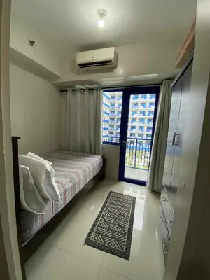 a small bedroom with a bed and a window at Bj's Staycation Manila - SEA Residences SM MOA in Manila
