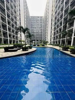 a large blue pool in a city with tall buildings at The Chill Spot Residences Property Management in Manila