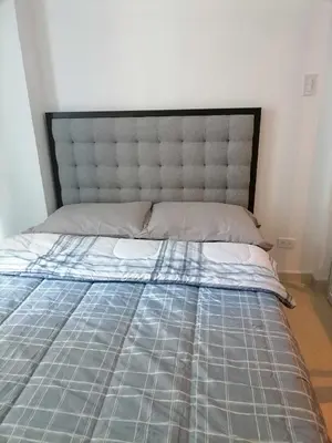 a bed in a room with a gray bed frame at Premium 1Bedroom Condo Unit Near Airport, MOA, Casinos, SM Bicutan in Manila