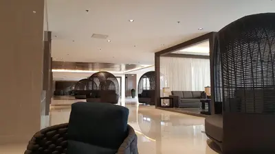 a lobby with a chair and couches in a building at My Serenity Suite in Manila
