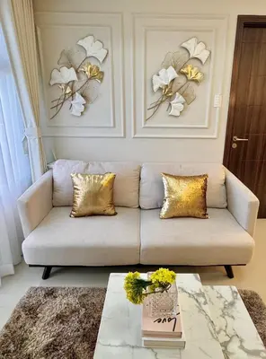 a living room with a couch and flowers on the wall at Manila Bay Suite in Manila