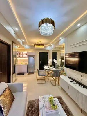 a living room with a white couch and a chandelier at Manila Bay Suite in Manila