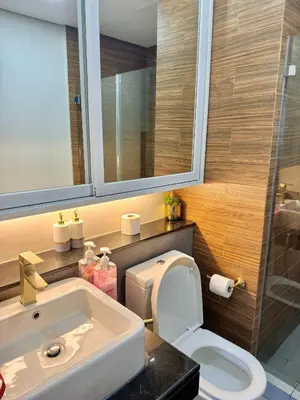 a bathroom with a sink and a toilet and a mirror at Manila Bay Suite in Manila