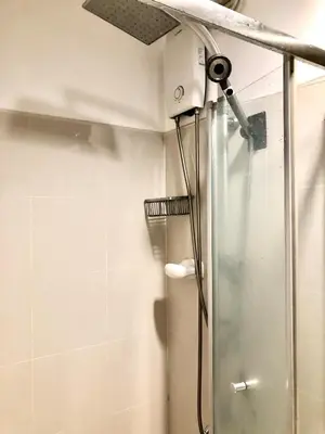 a shower with a ceiling fan in a bathroom at Cosy Light Residences Unit Staycation in Manila