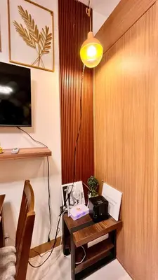 a room with a wooden wall with a table with a lamp at M&B Staycation in Manila