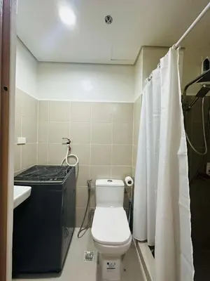 a small bathroom with a toilet and a sink at M&B Staycation in Manila
