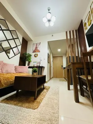 a bedroom with a bed and a table and a desk at M&B Staycation in Manila