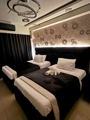 a bedroom with two beds and a chandelier at M&M Condostay at Shore 2 Residences Tower 3 in Manila
