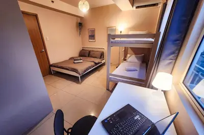 a small room with a desk with a laptop on it at Artsy 110sqm 2br in MOA 200mbps Wifi XBOX Printer in Manila