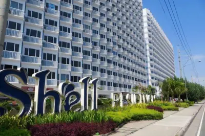 a large white building with a sign in front of it at Artsy 110sqm 2br in MOA 200mbps Wifi XBOX Printer in Manila
