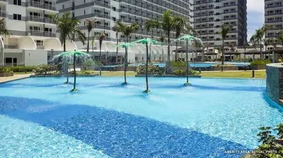 a large swimming pool with umbrellas on top of it at Artsy 110sqm 2br in MOA 200mbps Wifi XBOX Printer in Manila
