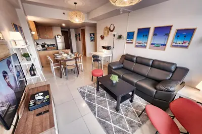 a living room with a leather couch and a table at Amazing View 2br MOA, 98 sqm XBOX 200mbps, Printer in Manila