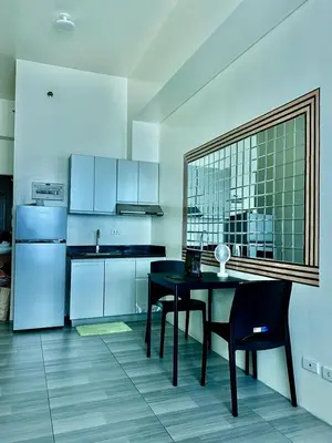 a kitchen with a black table and black chairs at The Beacon Tower in Manila
