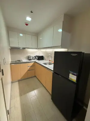 a kitchen with a black refrigerator and a sink at Superior Studio Eastwood Global Plaza Luxury Residence in Manila