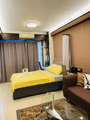 a hotel room with a bed and a couch at Shell Residences with MOA View near NAIA - Aiza's Place in Manila