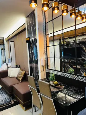 a living room with a couch and a table and chairs at Shell Residences with MOA View near NAIA - Aiza's Place in Manila