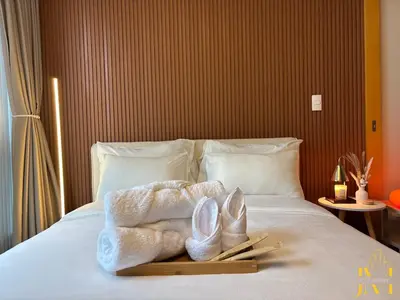 a tray with towels and shoes on a bed at Cozy & Aesthetic 1 BR in BGC in Manila