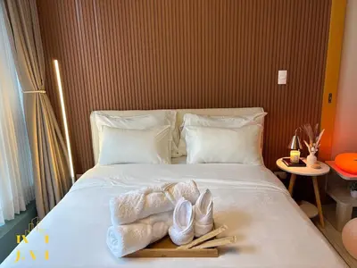 a bed with two pairs of shoes and a tray on it at Cozy & Aesthetic 1 BR in BGC in Manila