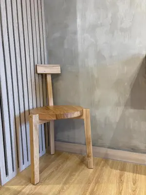 a wooden stool sitting next to a wall at 1LDK Air Studio in Makati City in Manila