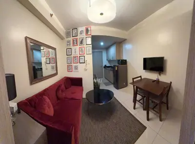 a living room with a red couch and a table at LALAROOMS - with Manila Bay Sunset View in Manila