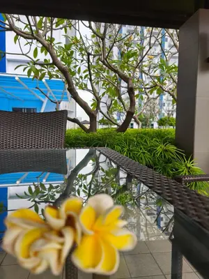 a glass table with yellow flowers on top of it at City Staycation Condo-SM Jazz in Manila