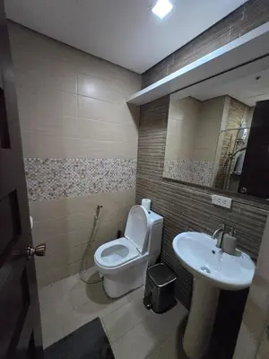 a bathroom with a toilet and a sink at Central BGC - Spacious Modern 2 bedrooms 2 bathrooms with Balcony in Manila