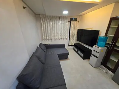 a living room with a couch and a flat screen tv at Central BGC - Spacious Modern 2 bedrooms 2 bathrooms with Balcony in Manila