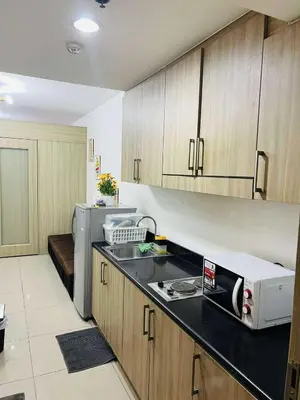 a kitchen with a sink and a microwave at The Cozy Corner in Manila