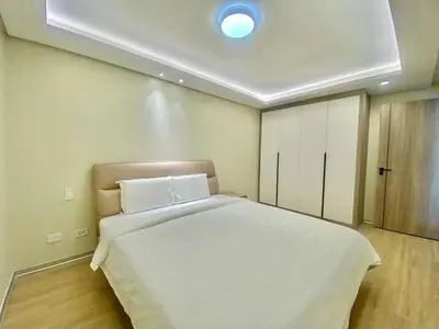 a bedroom with a white bed with a ceiling at City Center Executive Hotel-Near Manila Airport and PITX in Manila