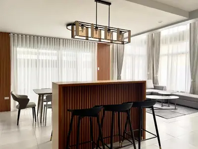 a kitchen and living room with a bar and chairs at CASA GUADA - Villa & Pool House Staycation in Postema