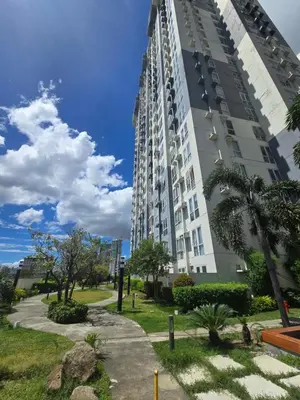 a tall white apartment building with a sidewalk and palm trees at Casa de Porch in Manila