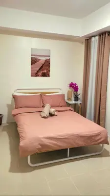 a bedroom with a bed with pink pillows at Casa de Porch in Manila