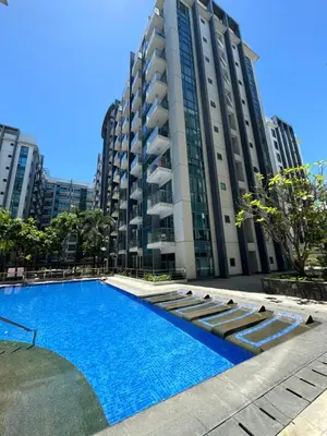 a swimming pool in front of a tall building at Pasay Airport Condotel by ASD in Manila