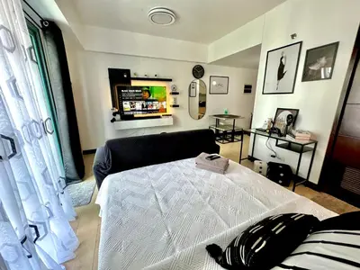 a living room with a bed and a couch at Pasay Airport Condotel by ASD in Manila