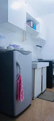 a kitchen with a refrigerator with a towel hanging on it at Guest house avida condo in Manila