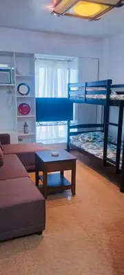 a living room with a couch and bunk beds at Guest house avida condo in Manila