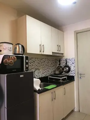 a kitchen with a black refrigerator and white cabinets at Staycation sa Jazz by Amaya 3921 Tower B in Manila