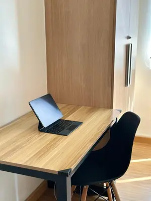 a laptop computer sitting on top of a wooden desk at Azure staycation by marco in Manila
