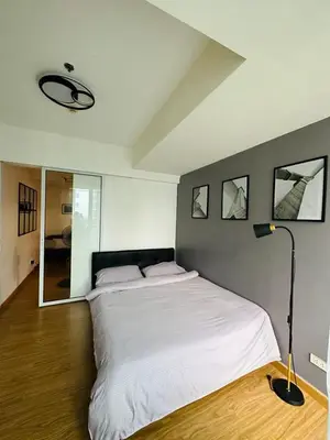 a bedroom with a large white bed and a lamp at Azure staycation by marco in Manila