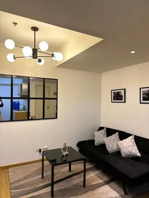a living room with a black couch and a table at Azure staycation by marco in Manila
