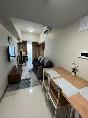 a living room with a couch and a table at Uptown Parksuite 1 BR Tower 2 BGC Taguig in Manila