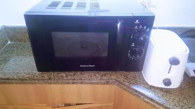 a microwave sitting on a counter next to a printer at Millionaire Makati Brio Tower in Manila
