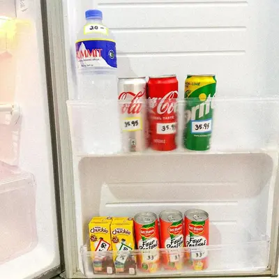 an open refrigerator with drinks and cans of soda at Crizzy's Hub Sariel at Shore Residences - 1BR with Netflix and Disney - Near MOA in Manila