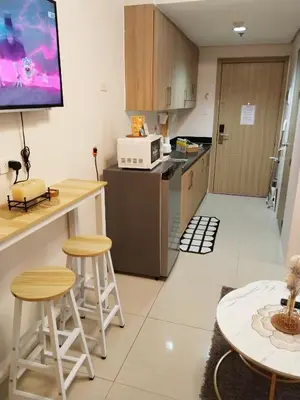 a kitchen with a counter and stools in a room at Crizzy's Hub Gabrielle at Shore Residences in Manila