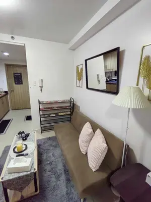a living room with a couch and a table at Mall of Asia's Staycation in Manila