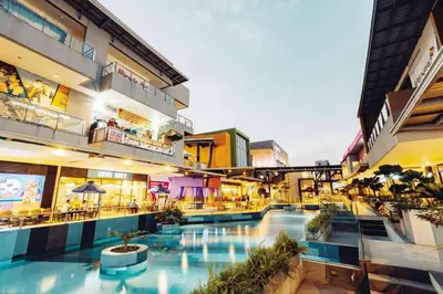 a building with a swimming pool in the middle at Circuit Suites in Manila