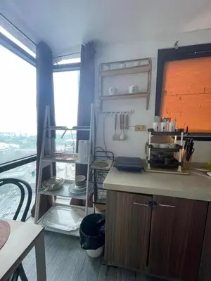 a kitchen with a counter and a refrigerator and a table at Ortigas Condotel near Robinsons Galleria with free pool in Manila