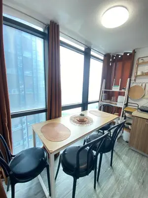 a table and chairs in a room with large windows at Ortigas Condotel near Robinsons Galleria with free pool in Manila