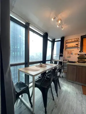 a kitchen with a table and chairs and windows at Ortigas Condotel near Robinsons Galleria with free pool in Manila